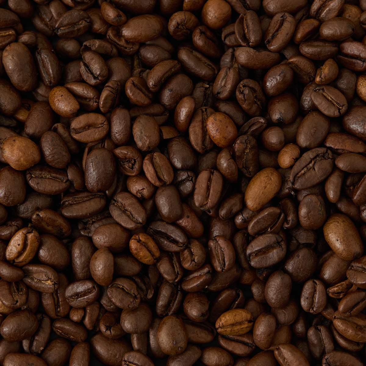 A close-up view of a pile of Mocha Djimmah Coffee beans, highlighting their dark brown color and textured surfaces.