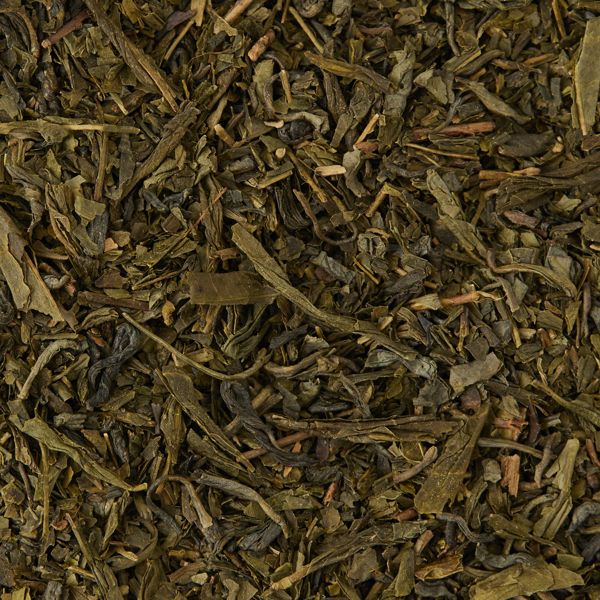 A close-up view of Classic Green Tea showcases loose, dried leaves in various shades of green and brown, featuring irregular shapes and textured surfaces.