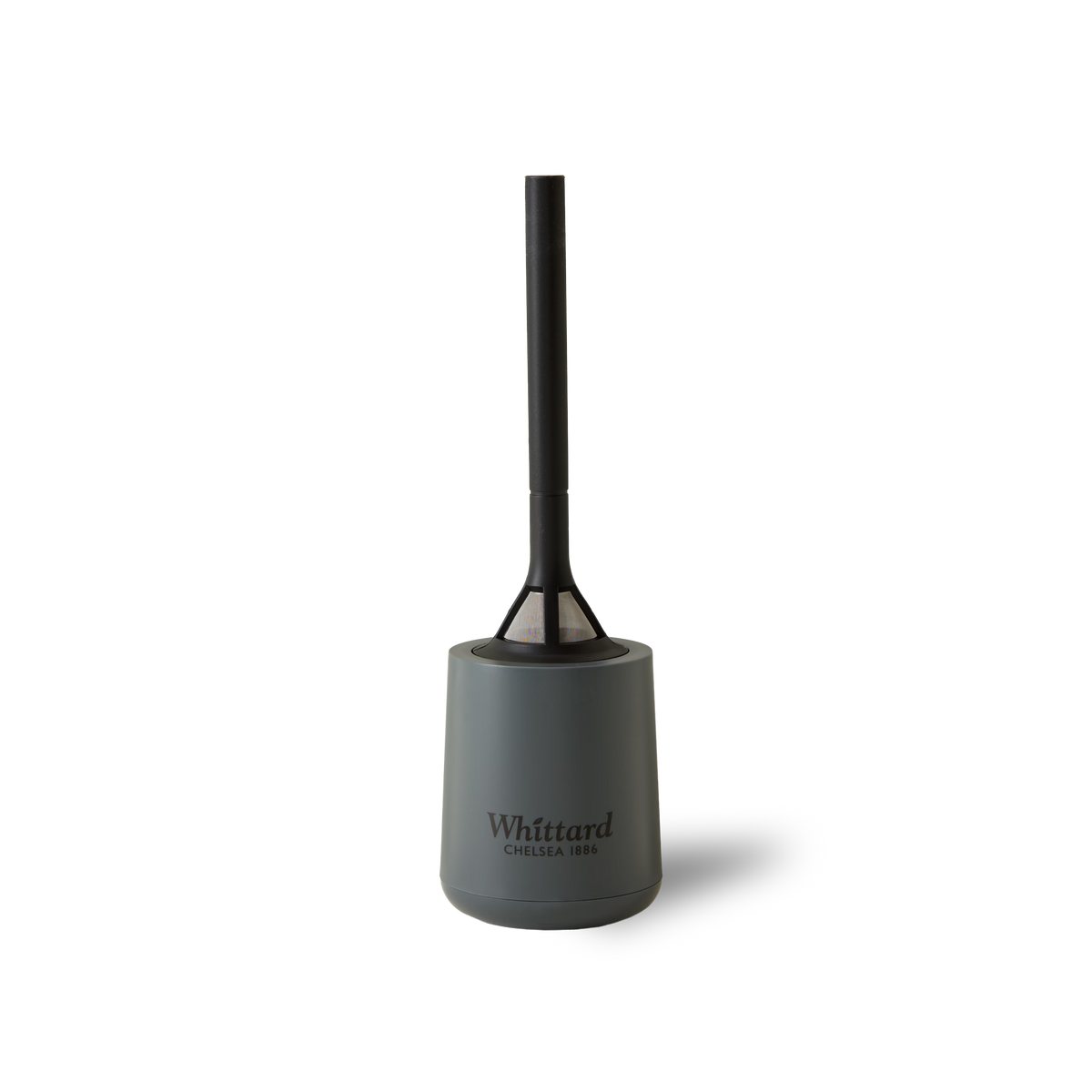 A gray toilet brush with a black handle stands upright in its matching holder, featuring the Whittard Brew It Stick logo on the front and evoking the distinctive design of their reusable coffee filter, set against a plain white background.