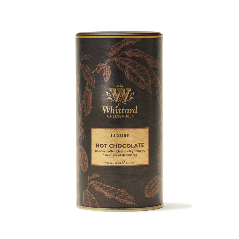 A cylindrical tin of Whittard Luxury Hot Chocolate with gold and brown botanical designs, featuring the Whittard Chelsea 1886 logo and product description on the front.
