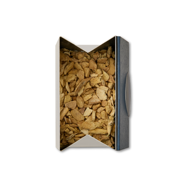 A plain white background showcases an open box of Pure Ginger Loose Infusion, filled with irregularly shaped pieces of dried ginger viewed from above.