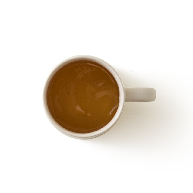 An Arran Mug in a large cream glaze stoneware finish, filled with light brown tea and viewed from above on a plain white background.