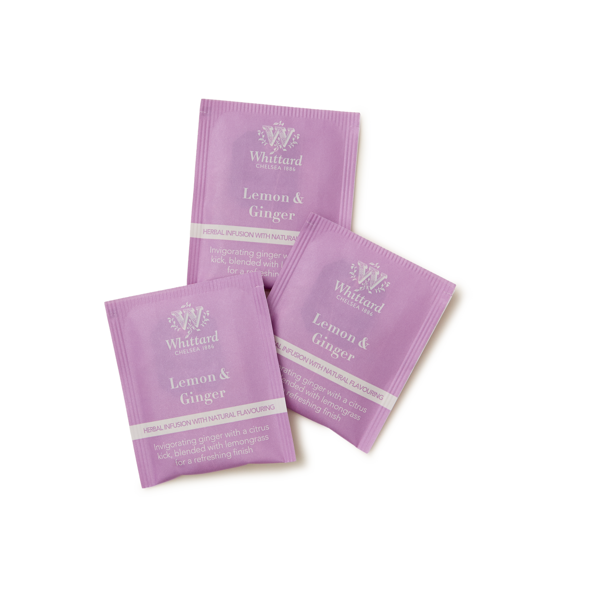 Three purple sachets of Whittard Lemon & Ginger Infusion Teabags are arranged on a white background. The sachets display the brand name and product name in white text, along with a brief description of the tea blend.