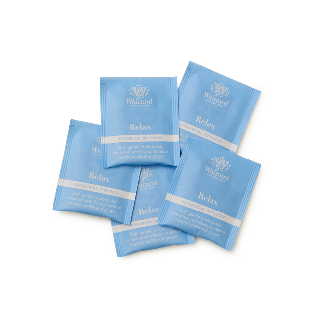 Five overlapping blue Relax Botanical Wellness Infusion Teabags from Whittard are shown, described as a calming herbal tea blend with soothing rooibos and creamy vanilla flavors, complemented by delicate notes of ginger.
