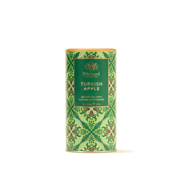 A cylindrical green tin of Turkish Apple Flavour Instant Tea, featuring an ornate pattern and a front label, captures the inviting spirit of Turkish hospitality with every sip of its authentic apple tea.