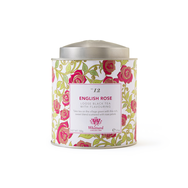The Tea Discoveries English Rose Tea Caddy is a decorative tin adorned with pink roses and green leaves, complete with a silver lid and a white label detailing its fragrant blend of Sri Lankan black tea infused with rose petals.
