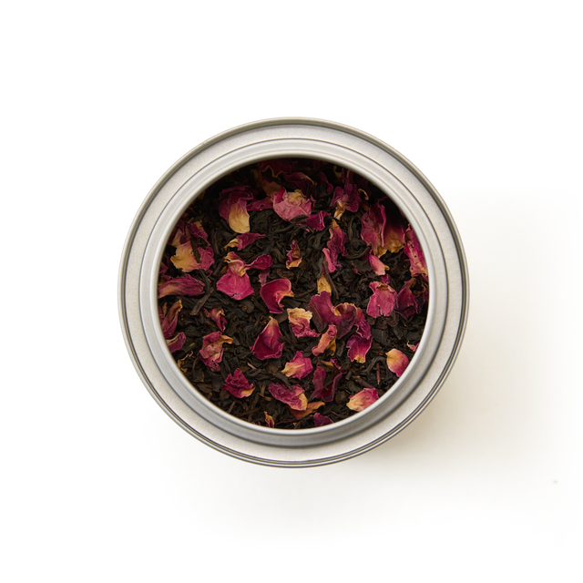 A Tea Discoveries English Rose Tea Caddy—a round metal tin filled with loose leaf English Rose tea, delicately blended with dried pink rose petals—viewed from above on a white background.