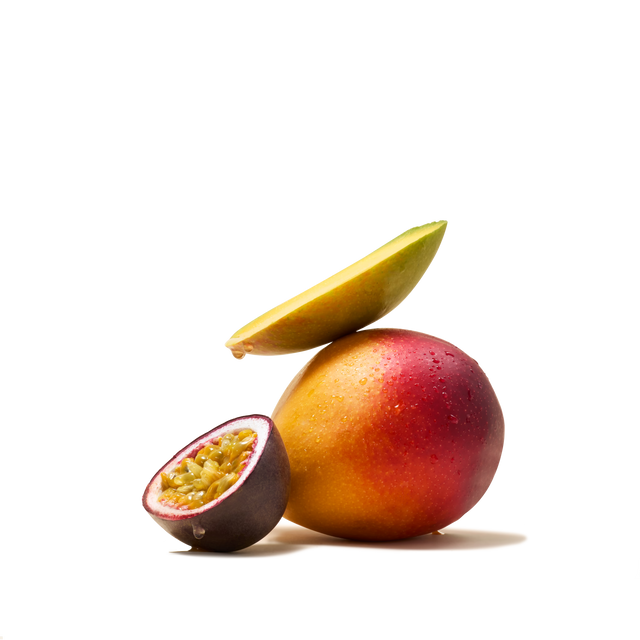 A whole mango topped with a slice sits beside a halved passion fruit filled with vibrant yellow seeds, set against a crisp white background—capturing the essence of Mango & Passionfruit Flavour Instant Tea and offering perfect inspiration for a refreshing tropical beverage or delightful fruit pairing.