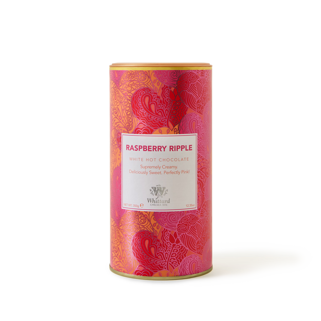 A cylindrical tin of Raspberry Ripple Flavour Hot Chocolate features a pink and red patterned design with a central white label, perfectly capturing the sweet indulgence of this unique white hot chocolate blend.