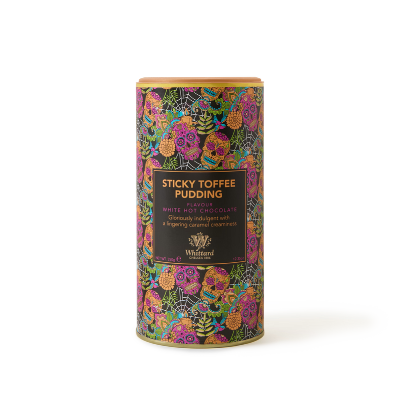 A vibrant tin of Sticky Toffee Pudding White Hot Chocolate, inspired by the classic British dessert, showcases a floral design with gold accents on its packaging.