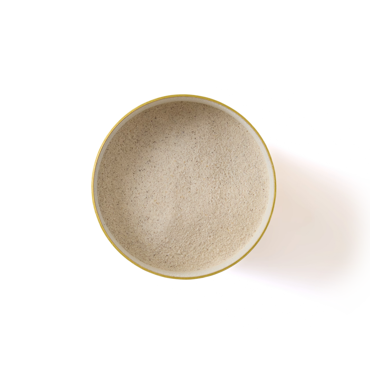 A round yellow bowl filled with Sticky Toffee Pudding White Hot Chocolate—a fine, light beige powder perfect for making classic British desserts—viewed from above on a white background.