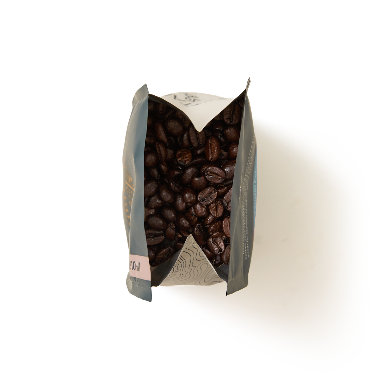 A top-down view of an open Guatemala Elephant Coffee Beans Valve Pack filled with dark roasted coffee beans, set against a white background.
