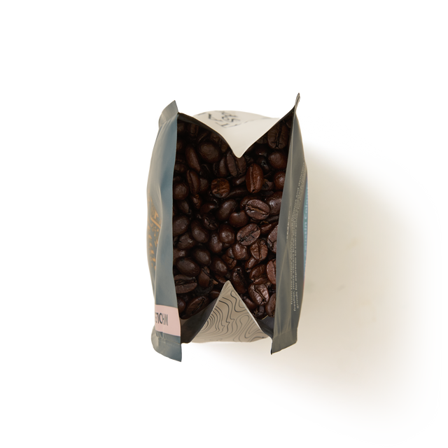 A top-down view of an open Guatemala Elephant Coffee Beans Valve Pack filled with dark roasted coffee beans, set against a white background.