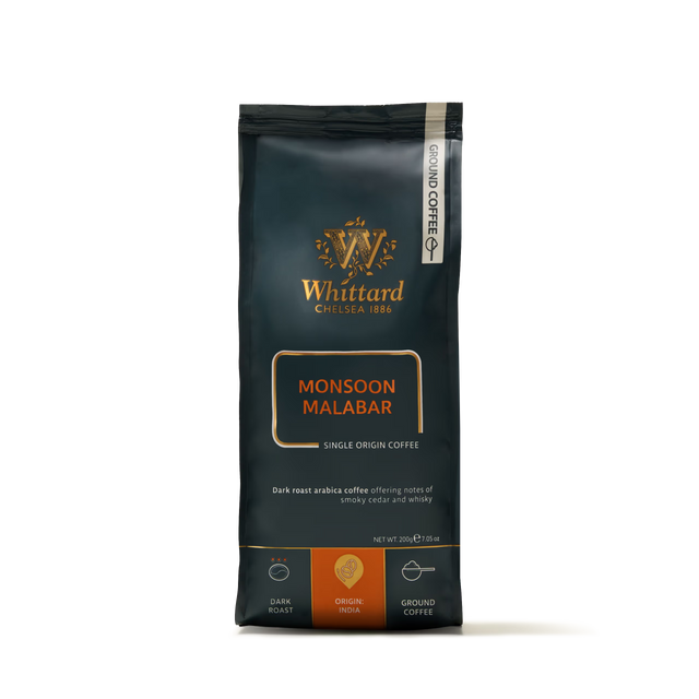 A bag of Monsoon Malabar Ground Coffee Valve Pack, a dark roast single origin Indian coffee, presented in black packaging with orange and gold accents and coffee details on the front.