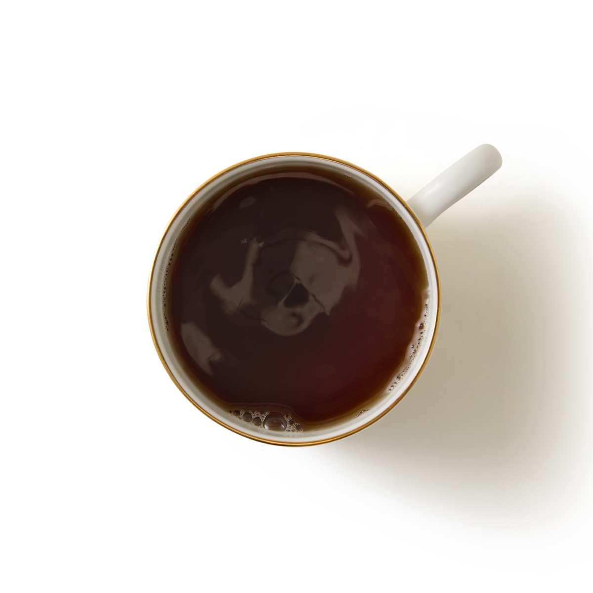 Top-down view of a white ceramic mug filled with Whittard House Blend Coffee Bags brew, placed on a white background. The handle is visible on the right side, and the coffee surface appears smooth with a few bubbles near the edge.
