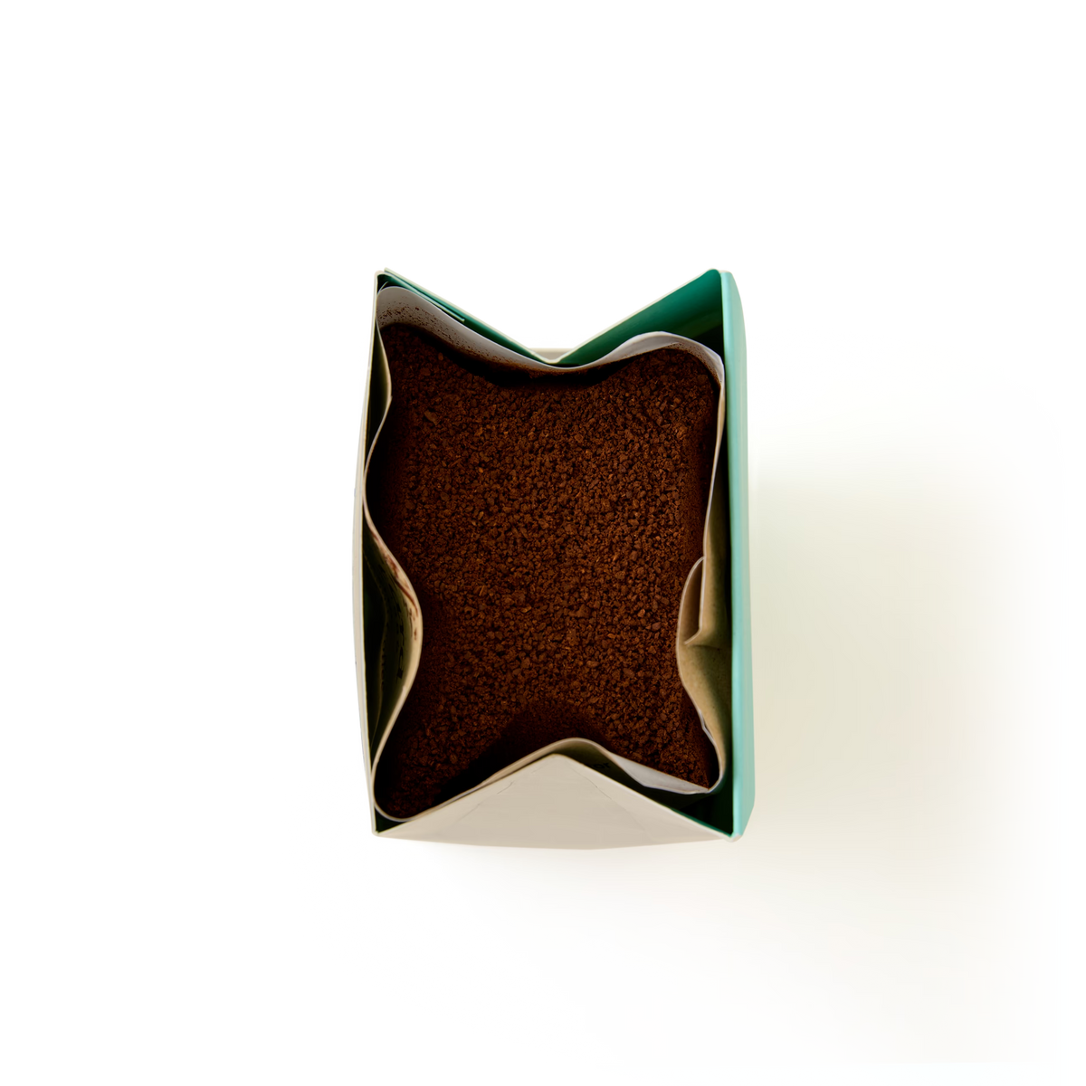 Open top view of a green paper bag filled with brown granular Amaretto Flavoured Ground Coffee against a white background.