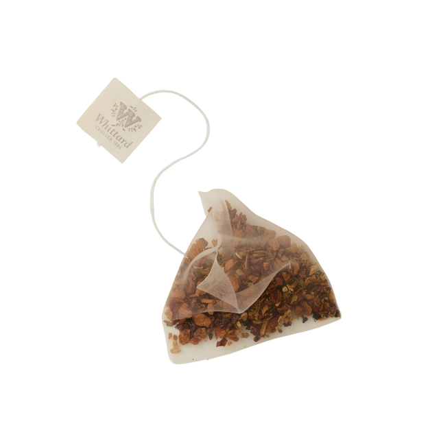 A pyramid-shaped Cold Brew Raspberry & Grapefruit Flavoured Infusion teabag filled with loose herbal tea leaves, perfect for a refreshing caffeine-free drink. Attached to a string with a Whittard tag, this blend delivers vibrant raspberry and grapefruit flavor and aroma. The product is set against a plain white background.