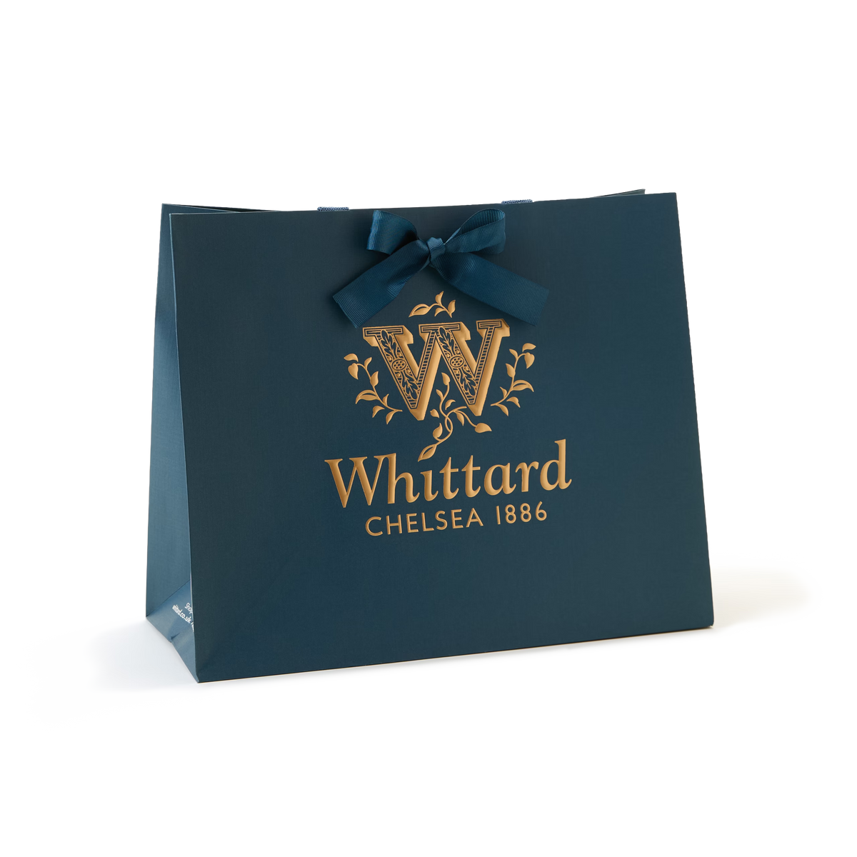A Luxury Gift Bag from Whittard of Chelsea in dark teal, featuring gold logo and “Whittard Chelsea 1886” text, finished with a matching teal ribbon bow—an elegant packaging choice perfect for any occasion.