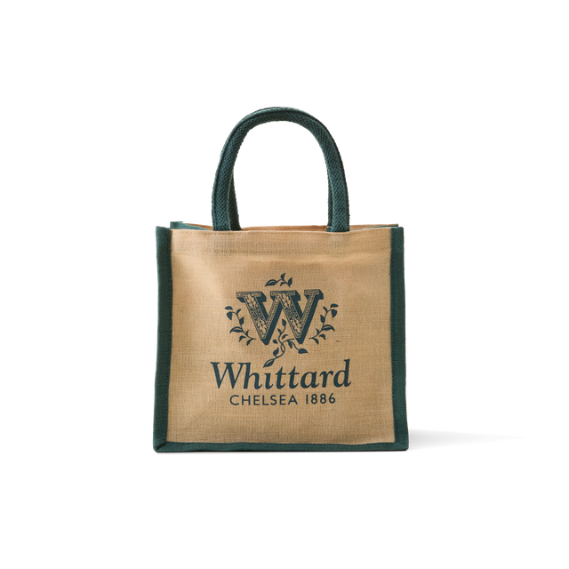 The Whittard Small Jute Cotton Bag, featuring tan and green jute cotton material with “Whittard Chelsea 1886” and a decorative W logo printed on the front, is displayed against a plain white background.