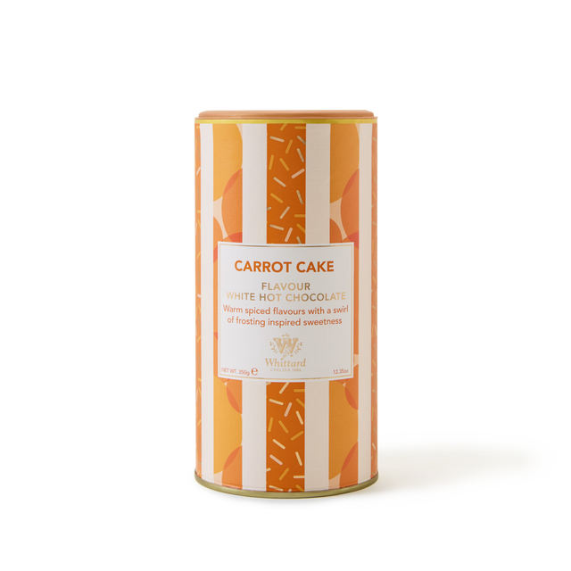 A cylindrical tin labeled Carrot Cake Flavoured Hot Chocolate, adorned with an orange and white striped pattern and sprinkles design, sits against a plain white background—ideal for savoring a cozy mug of creamy carrot cake hot chocolate.
