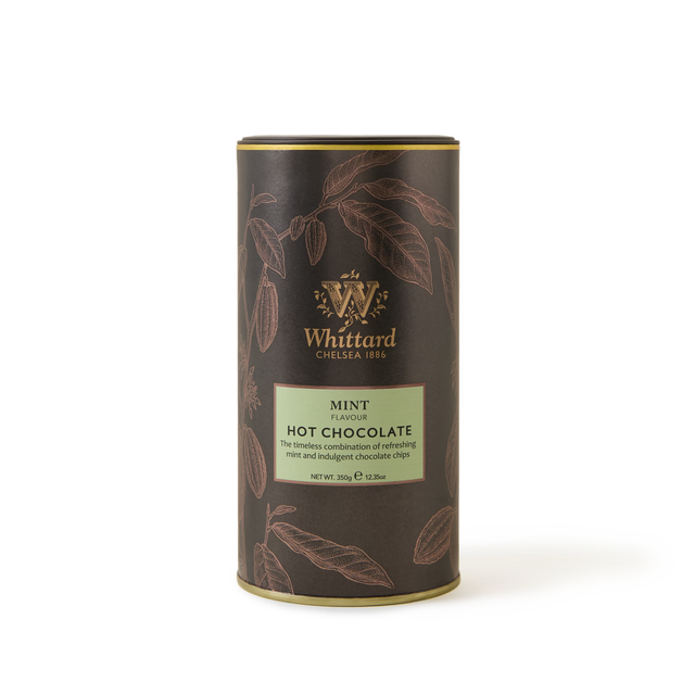 A cylindrical tin of Mint Flavoured Hot Chocolate with a brown and green label adorned with gold accents and cocoa pod illustrations on a white background—a luxurious chocolate mint beverage made with real chocolate chips for an irresistibly refreshing mint experience.