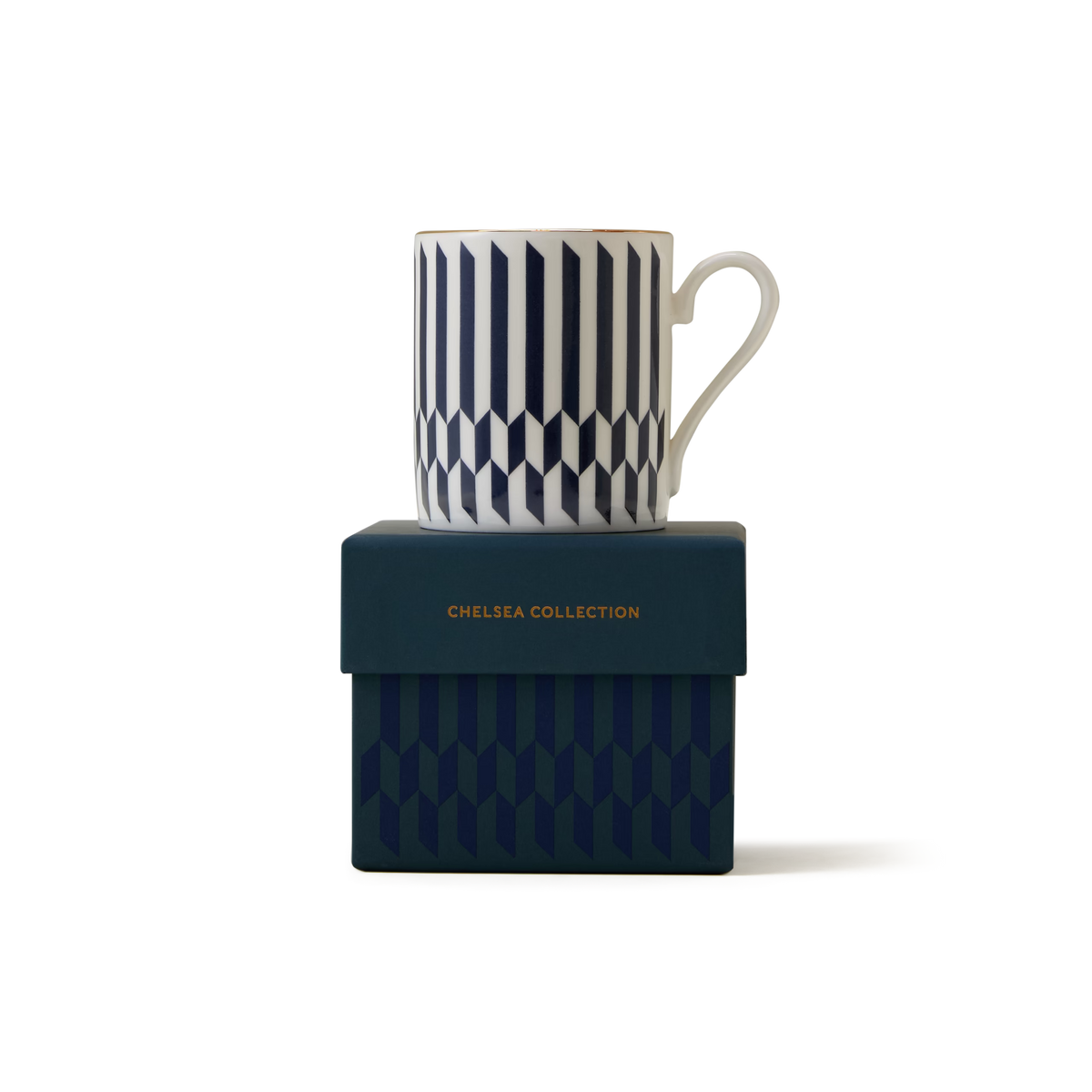 A white mug with a navy geometric pattern sits atop a matching dark blue box labeled Chelsea Collection in gold lettering. Both items have a coordinated design on a plain white background.