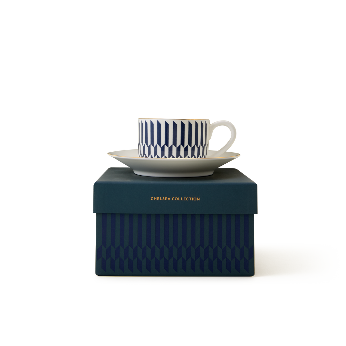 The Sloane Cup & Saucer, a white Chelsea teacup with a blue geometric pattern and matching saucer, rests on a dark blue box embossed with “Chelsea Collection” in gold lettering. Inspired by British ceramics, the set features elegant 22ct gold detailing, and the box is adorned with a coordinating geometric motif.