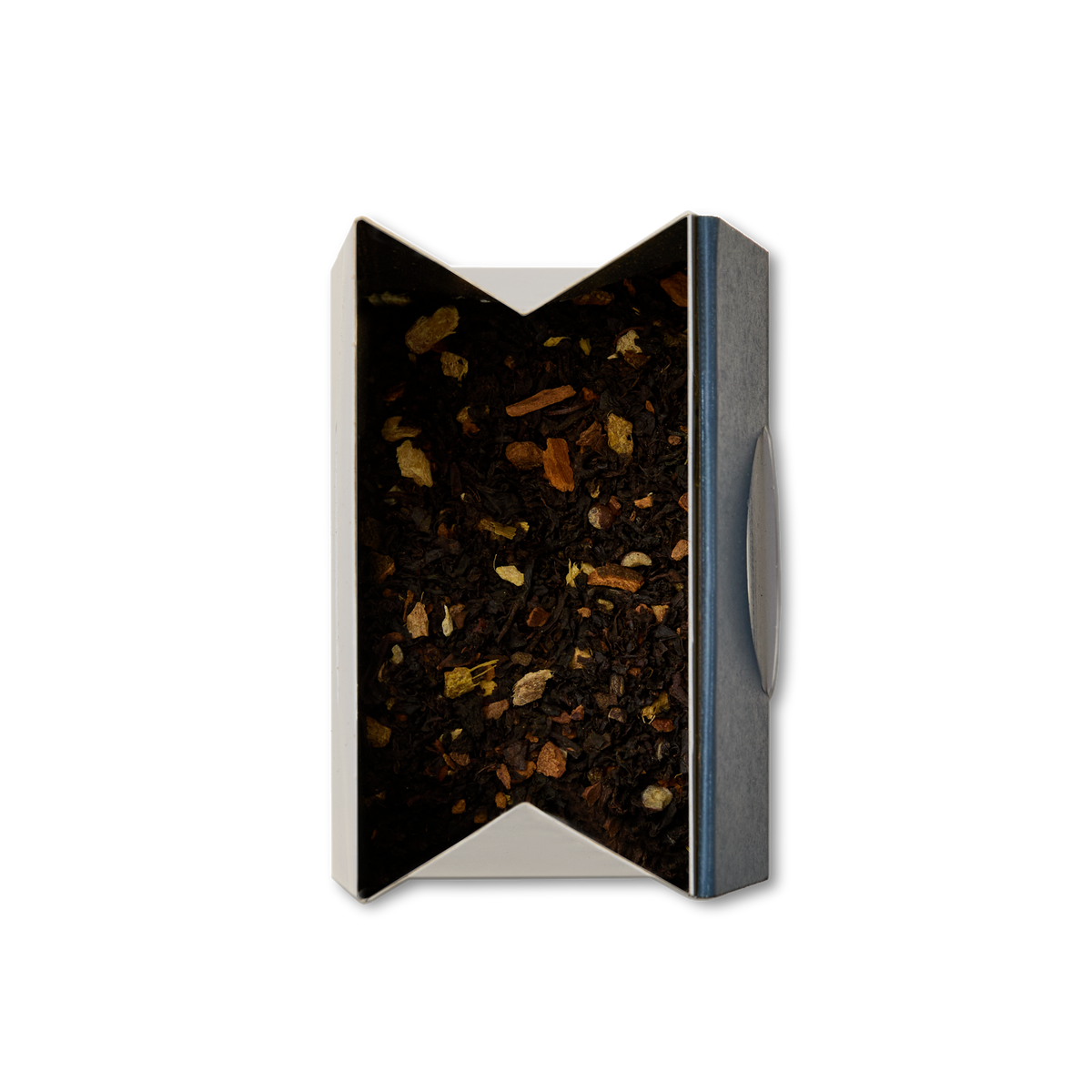 An open rectangular tin of Earl Grey Chai Loose Leaf Tea, viewed from above and filled with dark tea leaves blended with small pieces of spices or herbs.