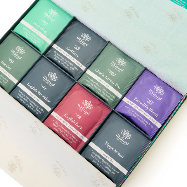 An open box displays nine assorted Whittard of Chelsea tea sachets in colorful packaging, including flavors like English Rose, Classic Green Tea, Jasmine, Earl Grey, and more, neatly arranged in three rows.