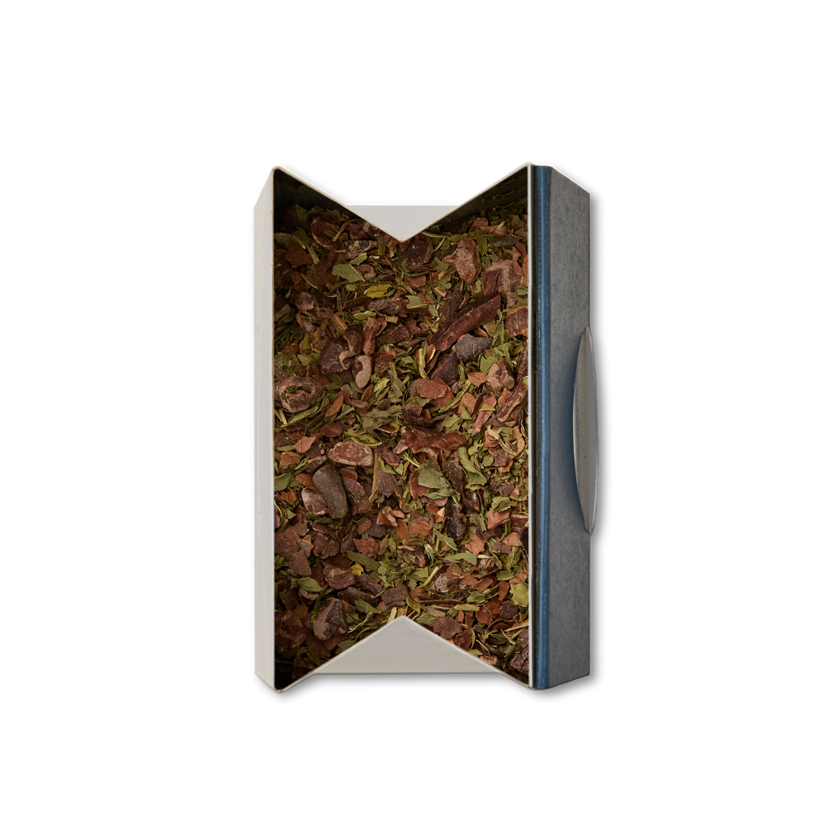 A rectangular box of Cacao & Mint Loose Infusion, filled with a blend of dried herbs and leaves seen from above. The open, angled top reveals the infusion's contents, framed by a simple dark rim on one side.
