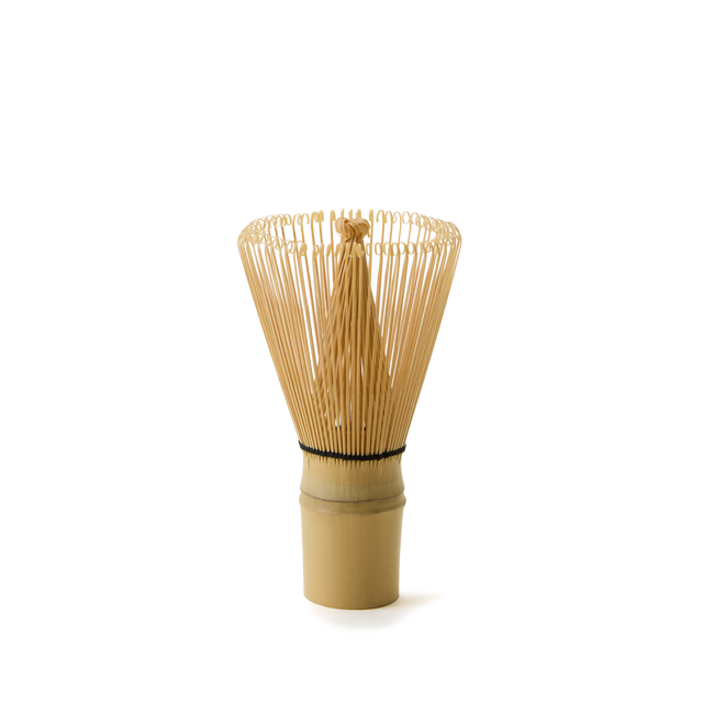 The Bamboo Matcha Whisk stands upright on a plain white background—an ideal choice for those looking for authentic tools for traditional matcha preparation.