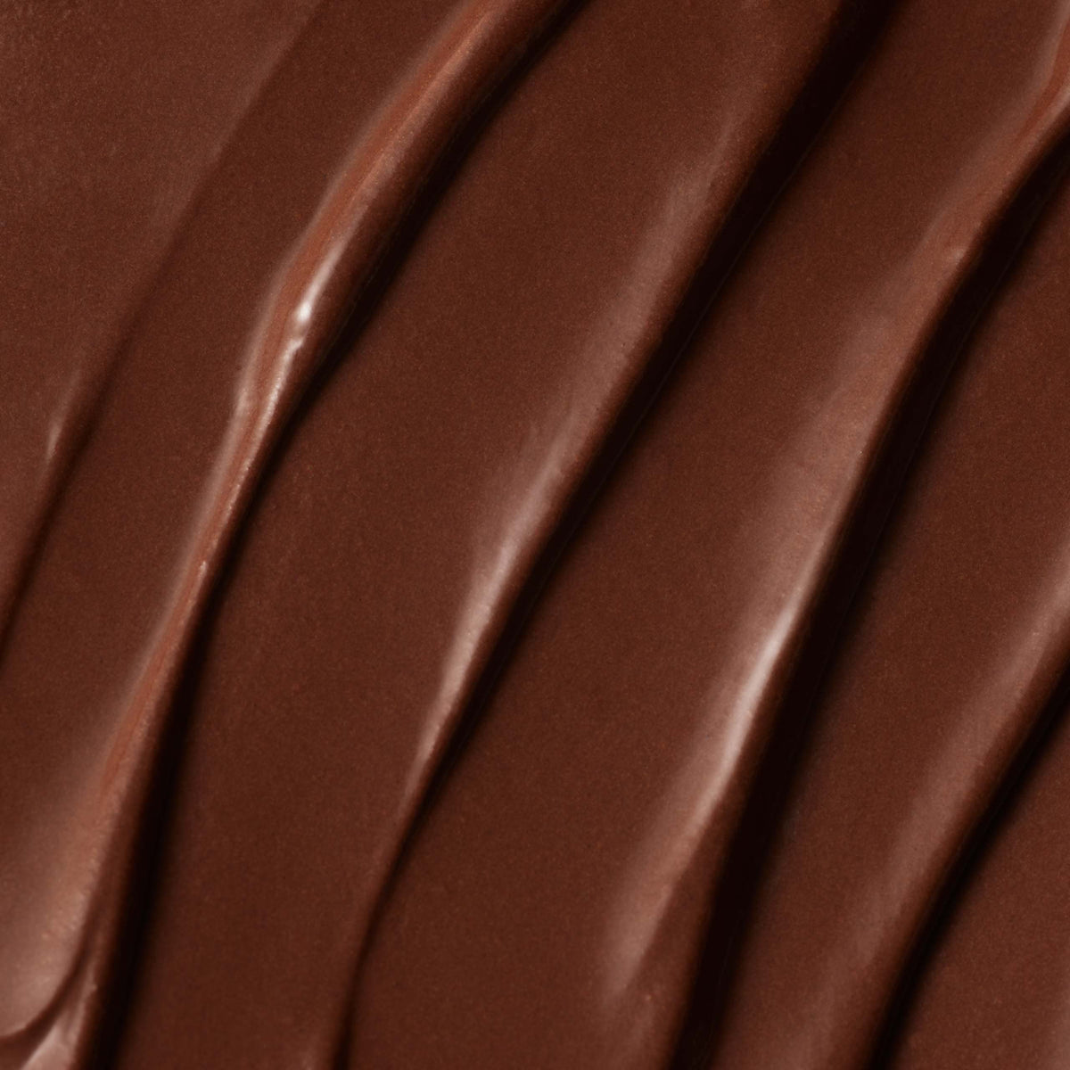 Smooth, close-up view of the Salted Caramel Milk Chocolate Bar, showcasing rich, creamy milk chocolate with wavy, textured lines running diagonally across the surface, crafted from single-origin Colombian cocoa.
