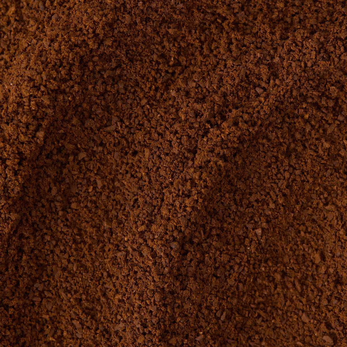 A close-up of finely ground Christmas Coffee from the Clip Top Tin, highlighting its rich brown color and slightly uneven, textured surface—a perfect festive blend for a memorable coffee gift.