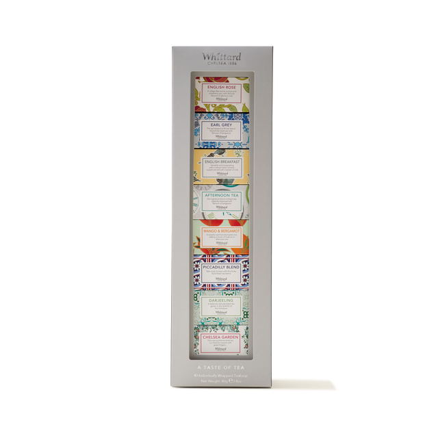A boxed gift set, Tea Discoveries A Taste of Tea, featuring eight Whittard assorted teas in colorful, uniquely designed packaging, neatly displayed vertically in a silver frame labeled "A Taste of Tea.