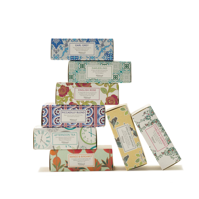 Stack of nine decorative tea boxes from Whittard’s "Tea Discoveries A Taste of Tea" collection, featuring various floral and patterned designs. Each box is labeled with a different tea flavor such as Earl Grey, Darjeeling, English Rose, and Mango & Bergamot. This beautifully arranged tea gift set presents an assortment of teas on a crisp white background.