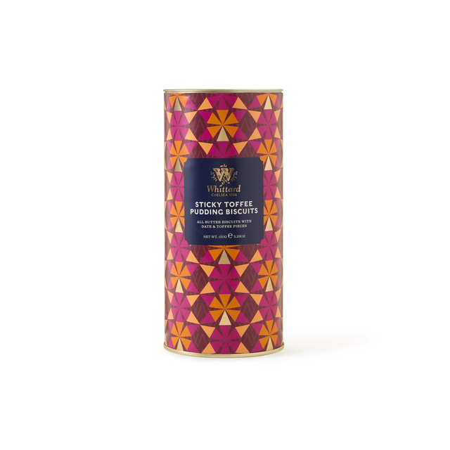 The Sticky Toffee Pudding Biscuits come in a cylindrical tin decorated with a bold geometric pattern in shades of red, orange, and pink, accented by a purple label on the front. These biscuits deliver the rich taste of classic puddings in every bite, making them an ideal gift for anyone who enjoys traditional British treats.