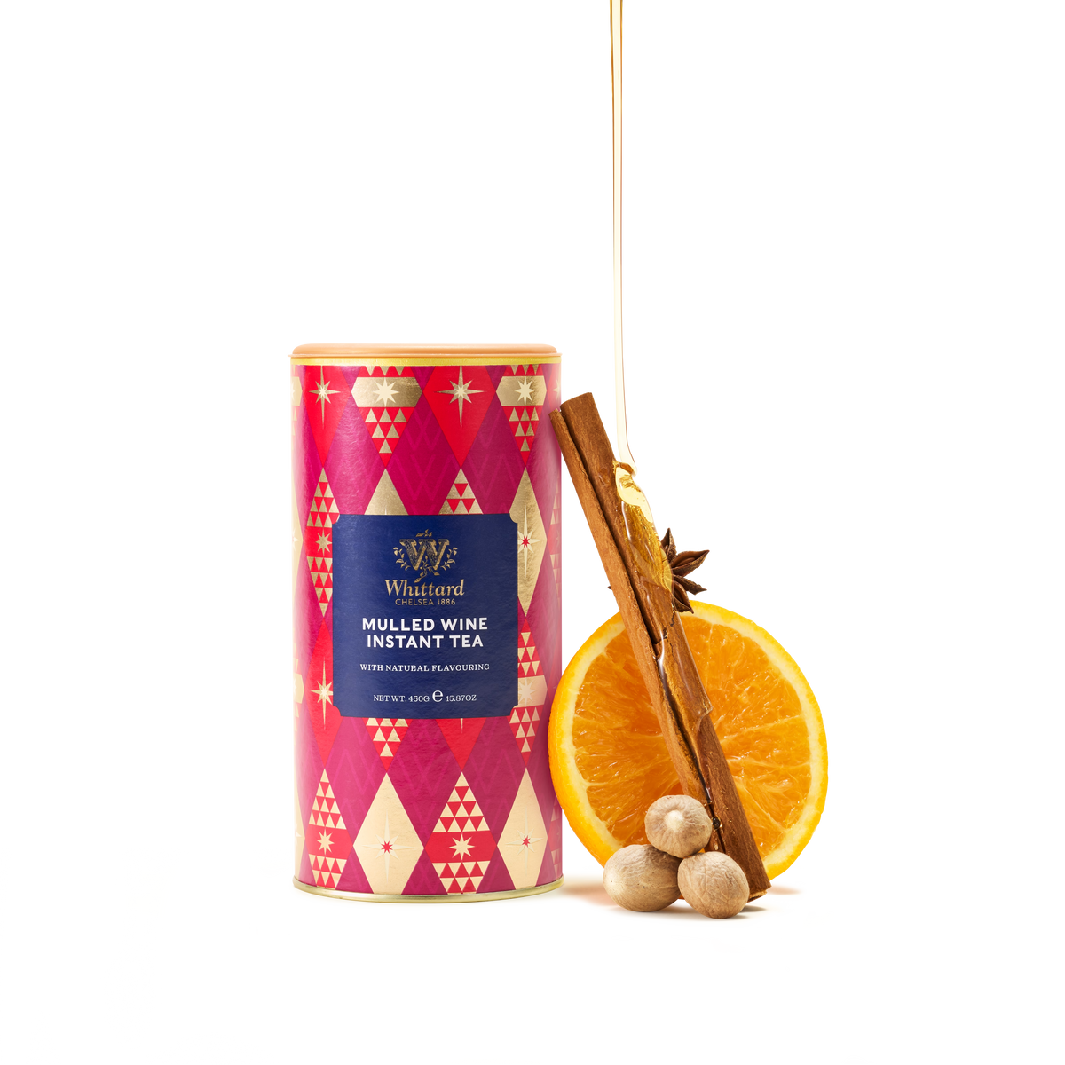 A canister of Mulled Wine Instant Tea, a delightful non-alcoholic festive drink, is placed beside a cinnamon stick, star anise, orange slice, and nutmegs, all arranged on a white background.