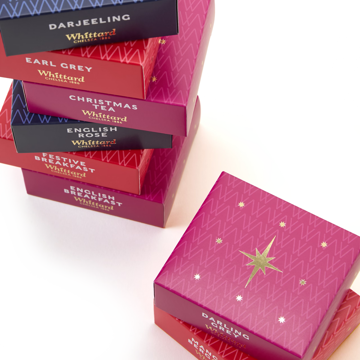 A Feast of Tea features a vibrant stack of Whittard tea boxes—Darjeeling, Earl Grey, Christmas Tea, English Rose, and Festive Breakfast—each adorned with festive star and zigzag designs, making it a delightful Christmas tea gift for enthusiasts or the perfect addition to any tea lover’s collection.