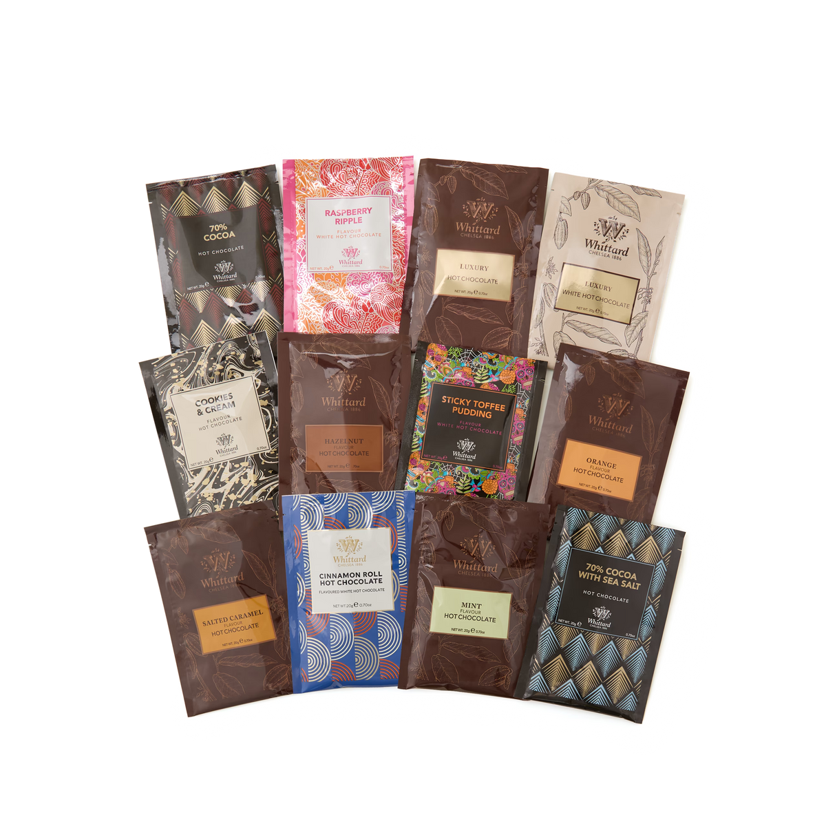 Twelve Hot Chocolate Advent Calendar packets arranged in a flat lay on a white background, each with different colorful, patterned packaging—including an indulgent carrot cake flavour that brings a unique twist to the selection.