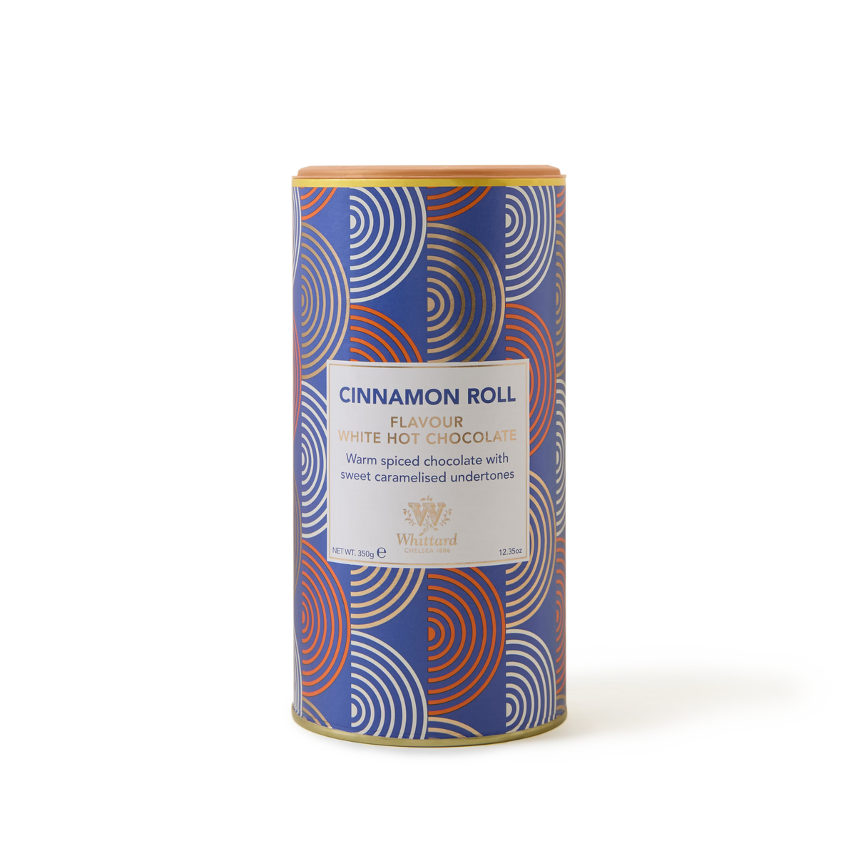 A cylindrical tin of Cinnamon Roll White Hot Chocolate featuring a blue, red, and white geometric-patterned packaging. The label describes this white chocolate drink as warmly spiced with sweet caramelised undertones, offering a delicious twist on classic cinnamon hot chocolate.