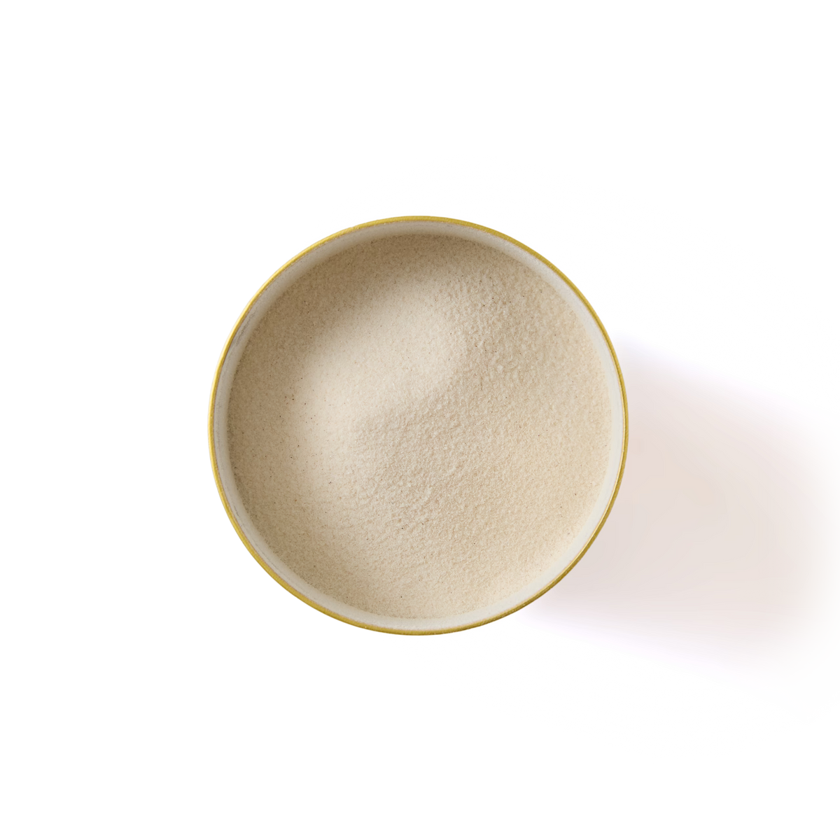 A top-down view of a round, yellow-rimmed bowl filled with fine, off-white powder on a plain white background.