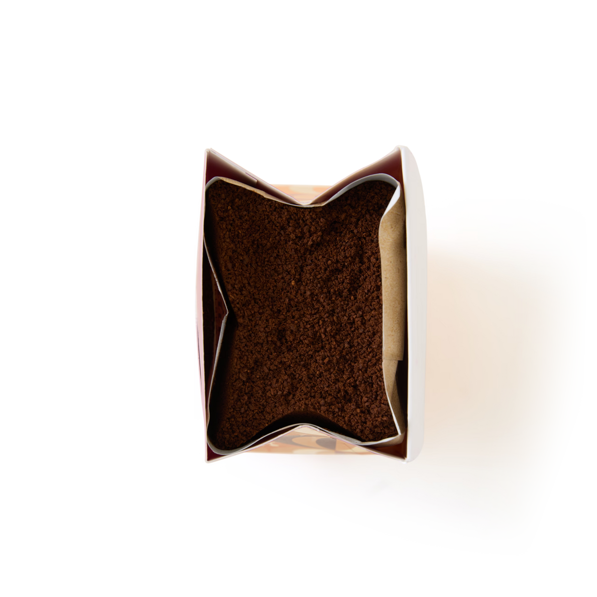 A top view of an open bag of Limited Edition Pumpkin Spice Flavour Ground Coffee, filled with rich brown grounds that evoke the inviting aroma of pumpkin spice, set against a clean white background.