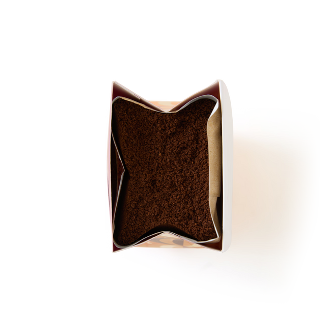 A top view of an open bag of Limited Edition Pumpkin Spice Flavour Ground Coffee, filled with rich brown grounds that evoke the inviting aroma of pumpkin spice, set against a clean white background.