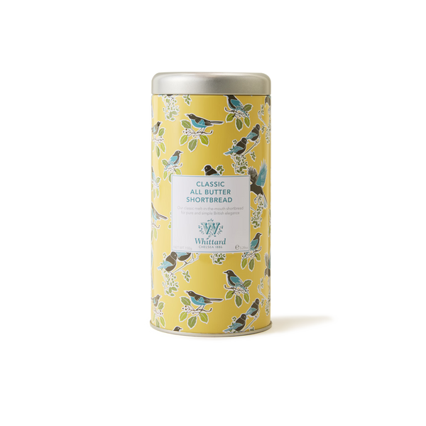 A yellow tin featuring bird and leaf illustrations, labeled Tea Discoveries Classic All Butter Shortbread Biscuit Tin by Whittard, sits against a plain white background—an inviting treat for any teatime biscuit lover in search of traditional British shortbread.