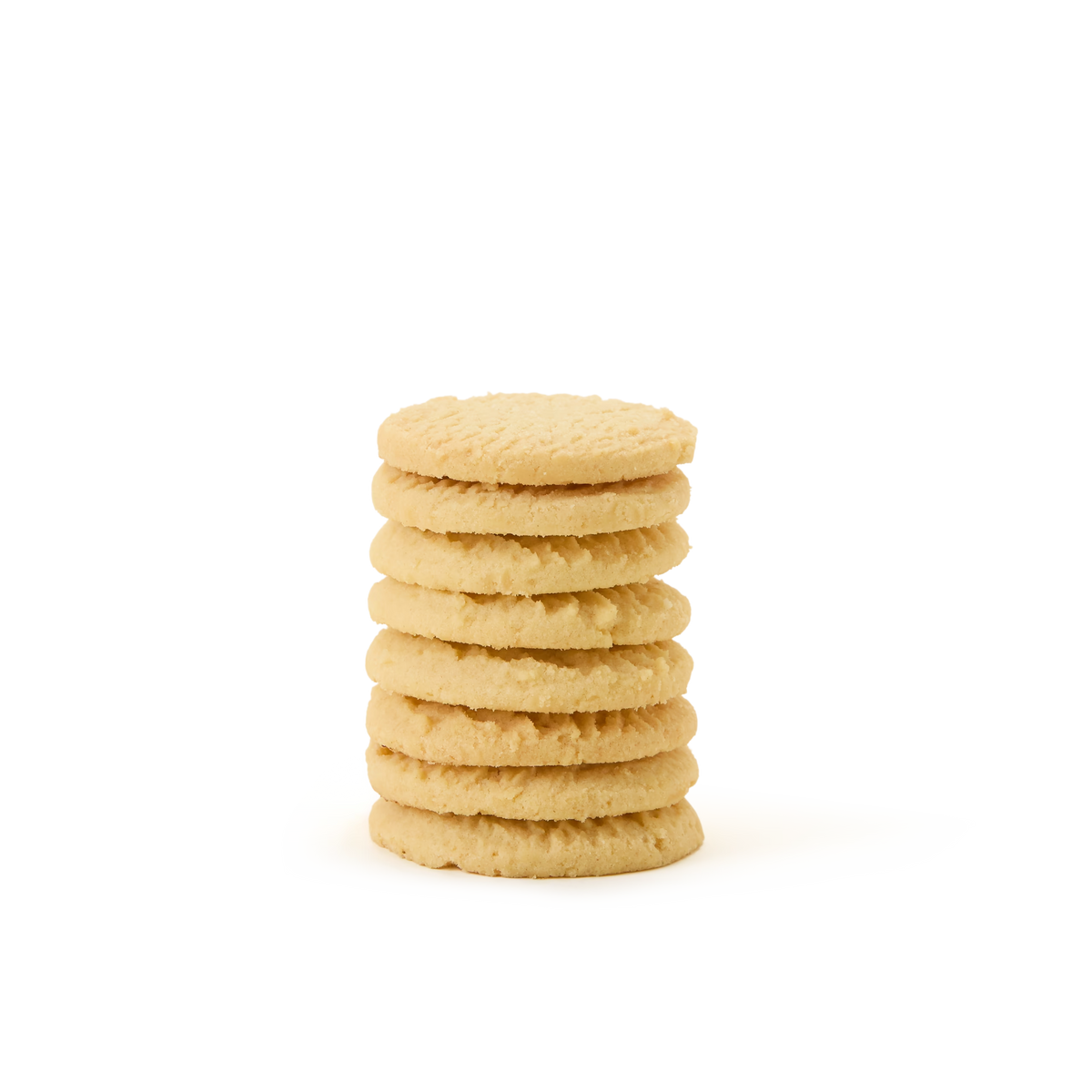 A stack of seven round, golden Tea Discoveries Classic All Butter Shortbread Biscuit Tin cookies on a plain white background.