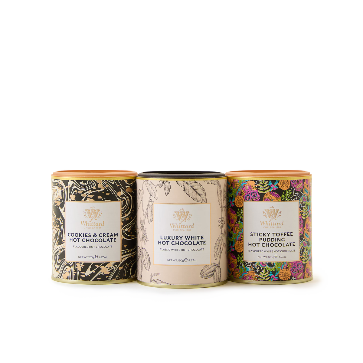 Three Whittard tins from the Hot Chocolate Curious Collection—Cookies & Cream, Luxury White, and Sticky Toffee Pudding—each featuring unique decorative patterns and labels, stand side by side against a white background.