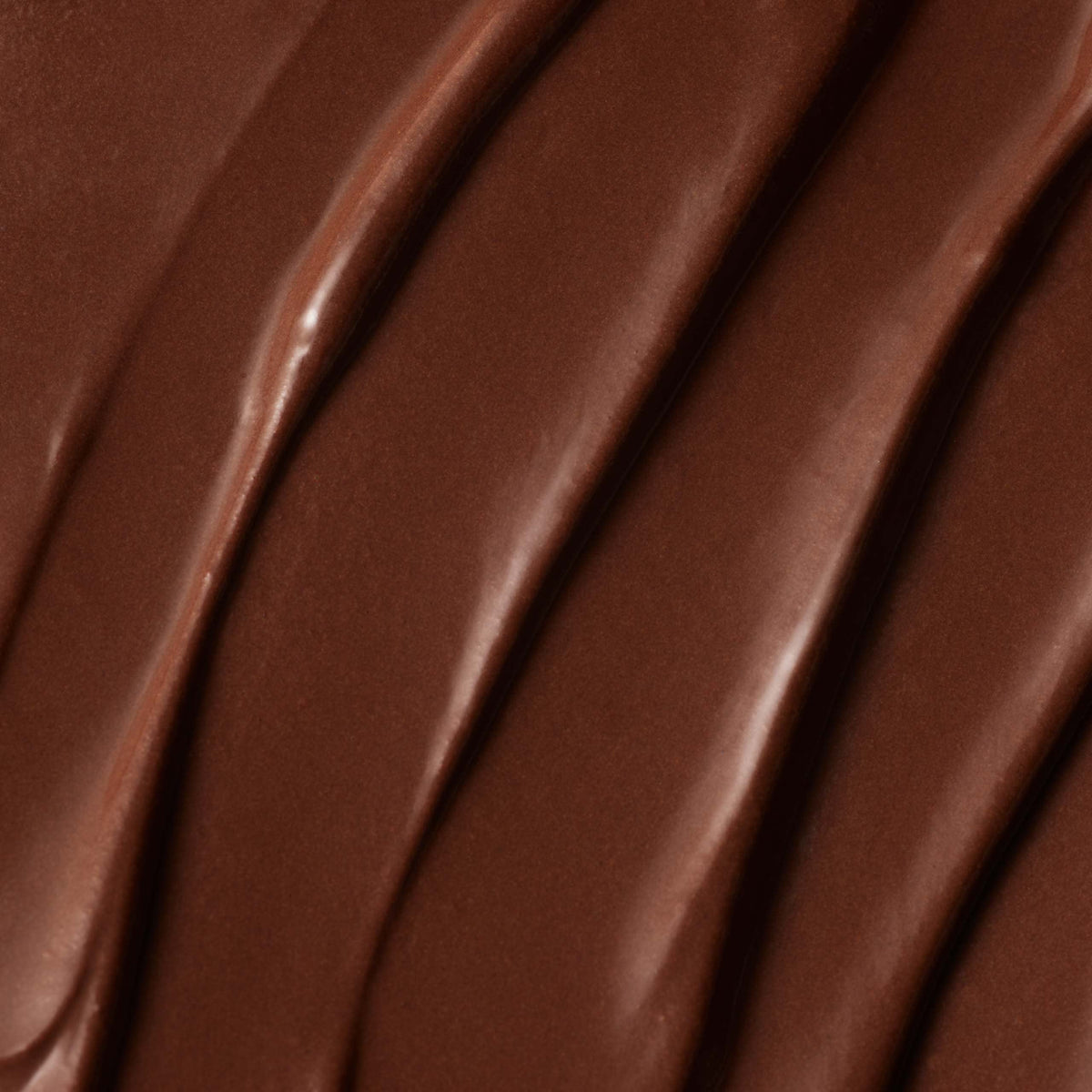Close-up of the Milk Chocolate Spoon with Marshmallows, featuring a creamy, glossy surface with smooth, wavy lines and a rich brown color.
