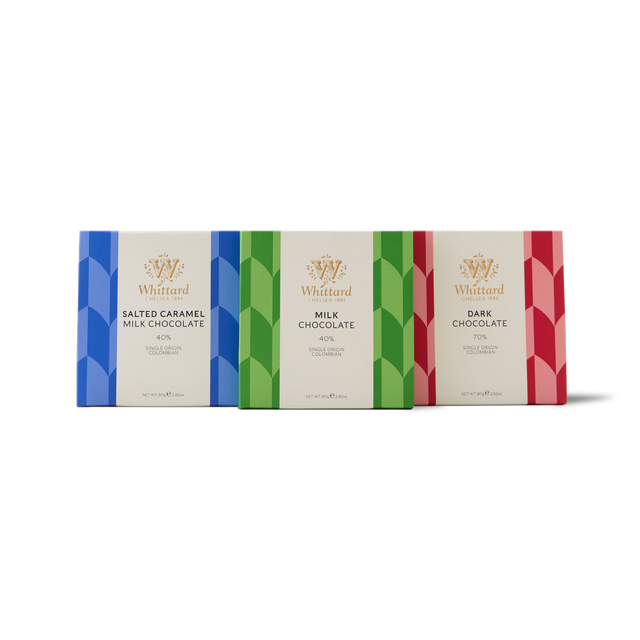 The Chocolate Bar Trio features three luxurious Whittard chocolate bars—Salted Caramel Milk Chocolate, Milk Chocolate, and Dark Chocolate—presented side by side in distinctive geometric-patterned wrappers (blue, green, and red). Crafted with single origin Colombian cocoa, this trio promises an indulgent and richly flavoured tasting experience.