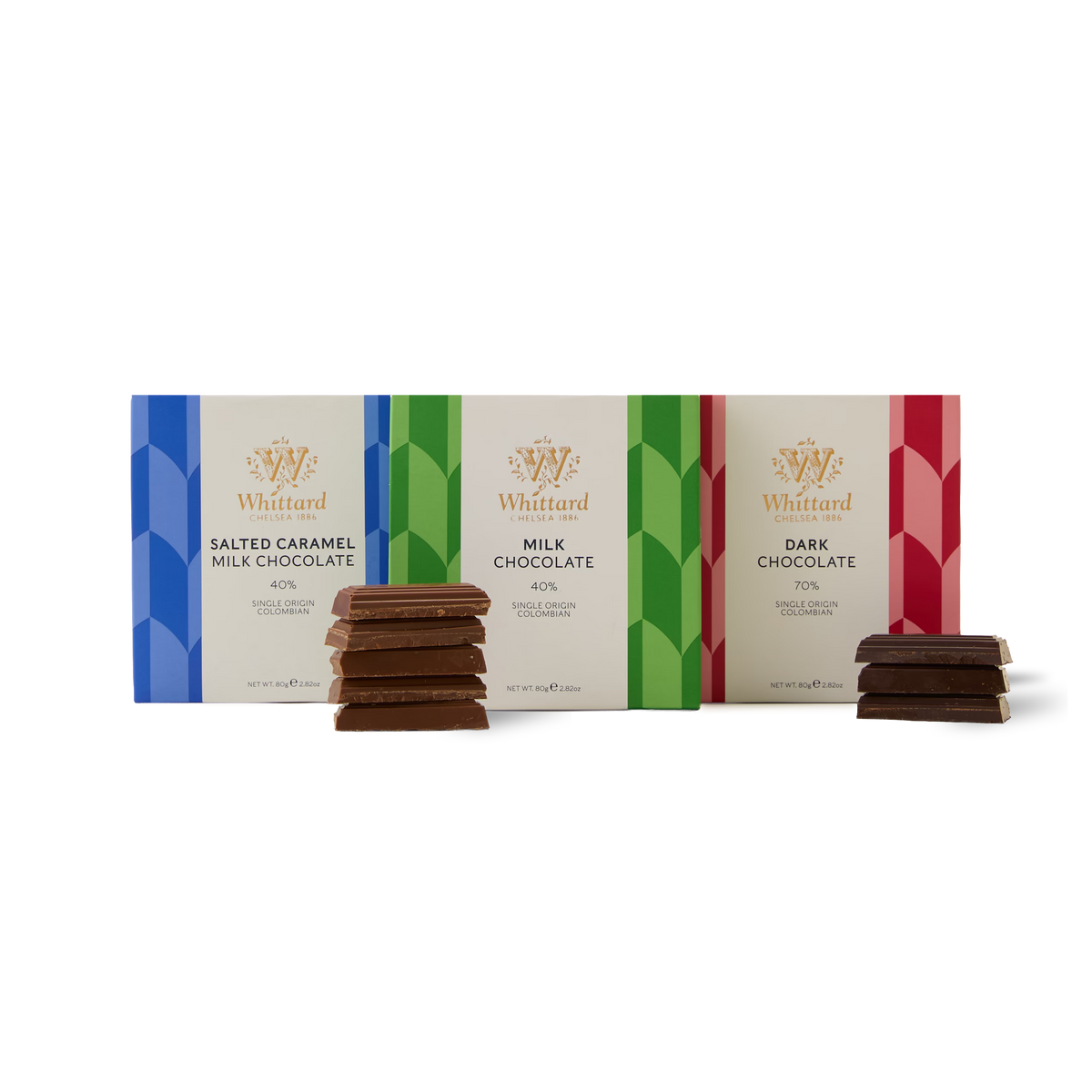 The Chocolate Bar Trio features three Whittard bars—Salted Caramel Milk, Milk Chocolate, and Dark Chocolate—each displayed with a small stack of chocolate pieces in front of their vibrant packaging on a white background, all crafted with single origin Colombian cocoa for an exceptional taste experience.