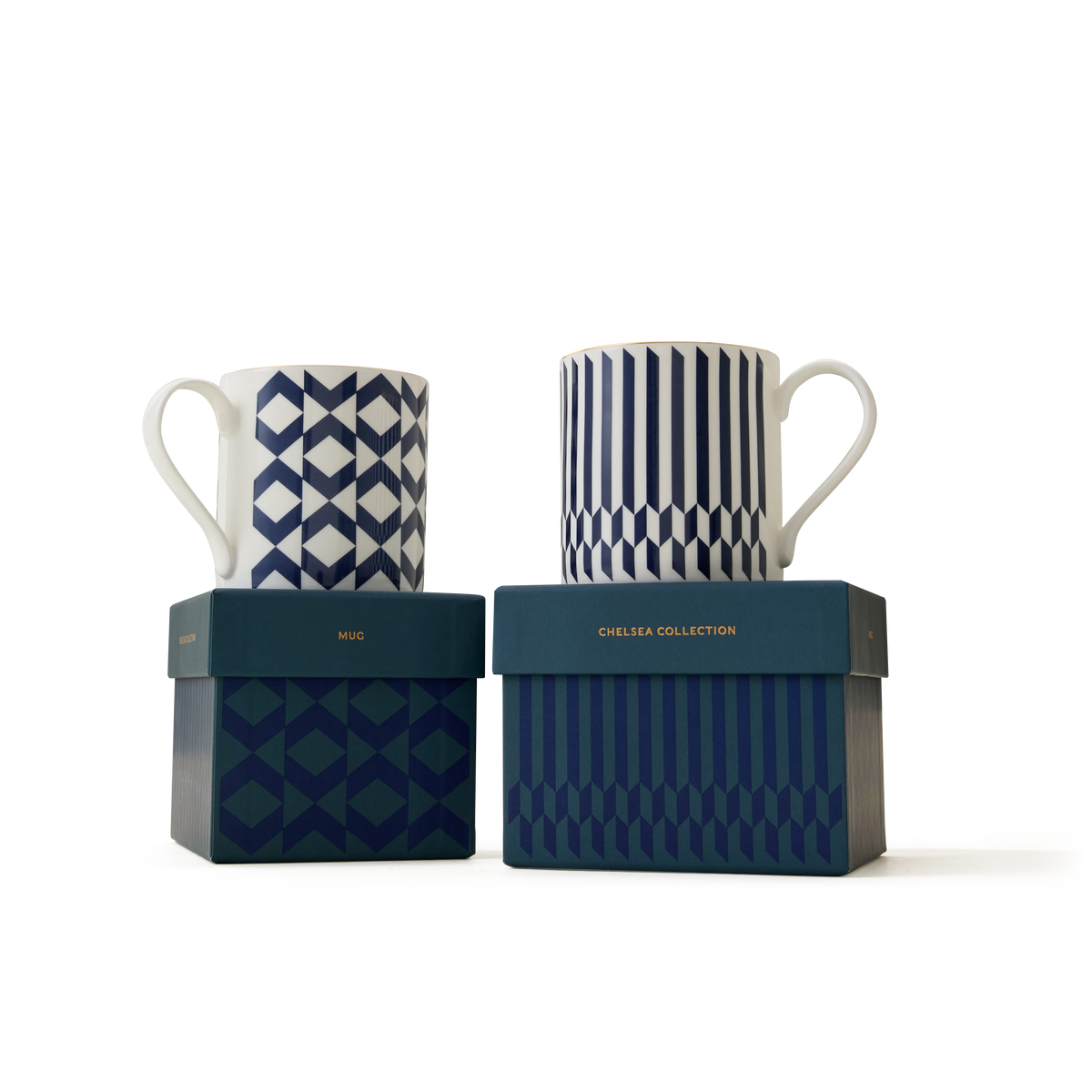 Two white mugs adorned with blue geometric patterns and elegant 22ct gold detailing sit atop matching blue boxes labeled “MUG” and “CHELSEA COLLECTION,” set against a plain white backdrop, showcasing the refined style of The Chelsea Collection Mug Duo and celebrating the excellence of British craftsmanship.